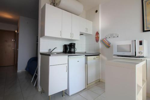エンプリアブラバにあるBasic Comfort Studio Miami 7º 0111の小さなキッチン(白いキャビネット、電子レンジ付)