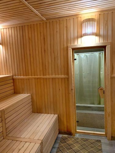a sauna with a window and a door to a tub at Терношорська Лада in Snidavka