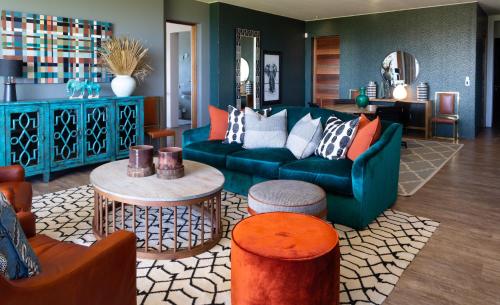 a living room with a blue couch and a table at Alkira Lodge in Brenton-on-Sea