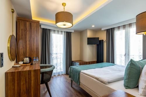 a hotel room with a bed and a desk and window at Interstar Hotel - Sultanahmet in Istanbul
