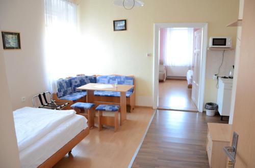 a room with a bed and a table and chairs at Penzion Mlýnický Dvůr in Červená Voda