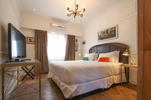 ブエノスアイレスにあるホテル クラシコのベッドとテレビが備わるホテルルームです。