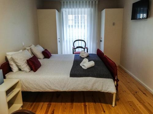 a bedroom with a bed with a teddy bear on it at Up Estalagem dos Padres in Albergaria-a-Velha