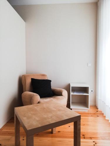 a living room with a chair and a table at Up Estalagem dos Padres in Albergaria-a-Velha