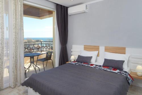 1 dormitorio con 1 cama grande y balcón en Niko's Sea View Apartments Deluxe en Nesebar