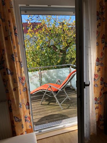 een glazen schuifdeur met een stoel op een terras bij 2 Zimmer Wohnung mit Balkon - Nähe Messe in Haar