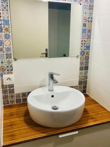 une salle de bain avec un lavabo blanc et un miroir dans l'établissement happiness Disney, à Saint-Germain-sur-Morin