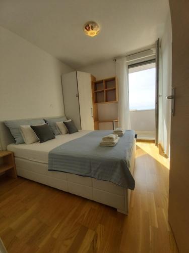 a bedroom with a large bed with a large window at Apartman Apollo 2 Makarska in Makarska