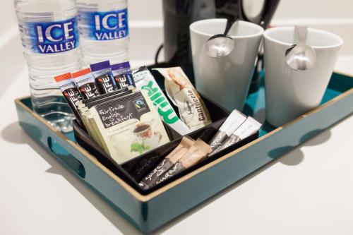 a tray with various items on a table with cups at Asperion Hillside Hotel in Guildford