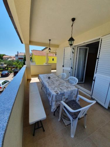 een patio met een tafel en stoelen op een balkon bij Apartments Vido in Vodice