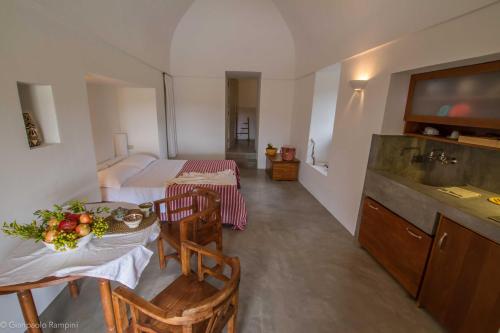 a kitchen with two tables and a sink in a room at 2 Gatti - Sogno in Pantelleria