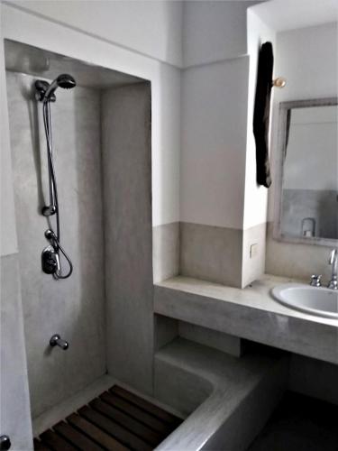 a bathroom with a shower with a sink and a mirror at 2 Gatti - Sogno in Pantelleria