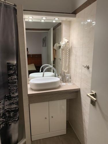 a bathroom with a sink and a mirror at Gästehaus Präsenzhof in Bensheim