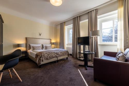 a hotel room with a bed and a couch at Jagdschloss Hotel Niederwald in Rüdesheim am Rhein