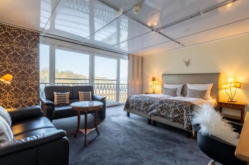 a hotel room with a bed and a balcony at Jagdschloss Hotel Niederwald in Rüdesheim am Rhein