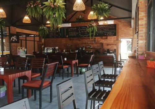 een restaurant met houten tafels en stoelen en een bar bij Aurora Resort Chiangdao in Chiang Dao
