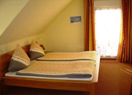 two beds in a room with a window at Pension Walddorf in Winterberg