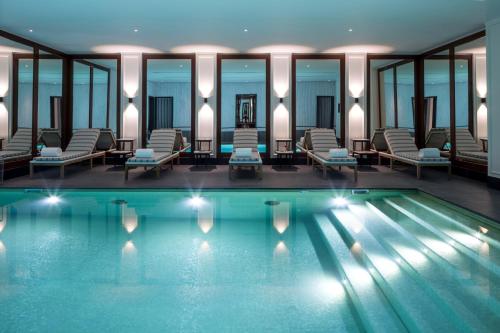 a pool in a hotel with chairs and a spa at J.K. Place Paris in Paris