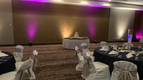 a banquet hall with two tables and chairs with purple lights at Holiday Inn Roanoke Airport - Conference CTR by IHG in Roanoke