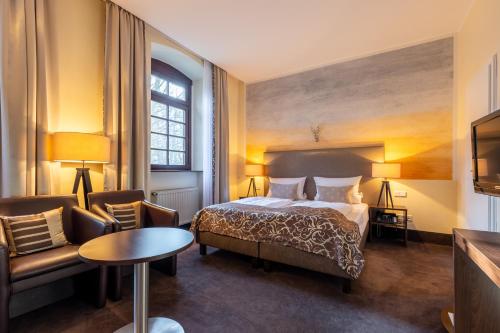 a hotel room with a bed and a chair at Jagdschloss Hotel Niederwald in Rüdesheim am Rhein