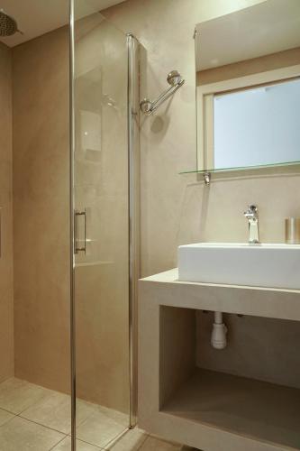 une salle de bain avec une douche en verre et un lavabo dans l'établissement Le Clos des Taulelles gîte Le Figuier, à Saint-Privat-de-Champclos