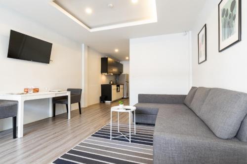 a living room with a couch and a table at Cozy Studio 1 in Sathorn, BTS Saint Louis in Bangkok
