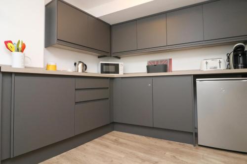 a kitchen with gray cabinets and a counter top at TOWN CENTRE apartment with parking in Padstow