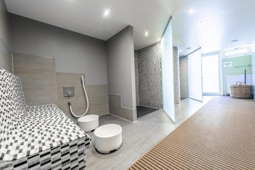 bagno con doccia e letto bianco e nero. di Raitelberg Resort a Wüstenrot