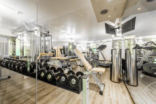 a gym with a lot of treadmills and machines at Raitelberg Resort in Wüstenrot