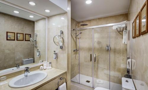 y baño con lavabo y ducha. en Sercotel Gran Hotel Conde Duque en Madrid