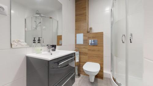 Un baño con inodoro, lavabo y ducha. en Apartament Świdnicka, en Wroclaw