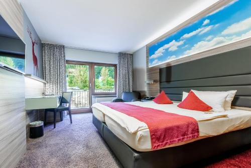a bedroom with a bed and a large window at Raitelberg Resort in Wüstenrot