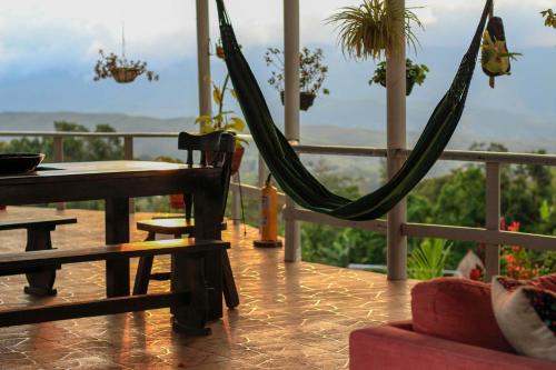 a porch with a hammock and a table and chairs at San Julio Campestre in Borrero Ayerbe