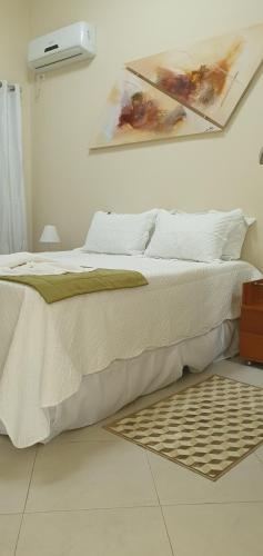 a bedroom with a bed with a painting on the wall at Cananeia Residencial in Cananéia