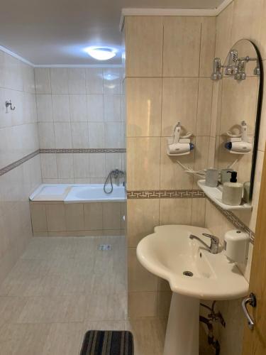 La salle de bains est pourvue d'un lavabo et d'une douche avec baignoire. dans l'établissement Hotel Rares, à Botoşani