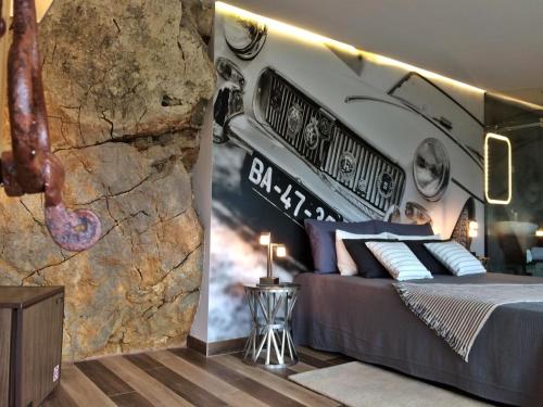 a bedroom with a bed and a stone wall at 1/4 na Serra in Rio Maior