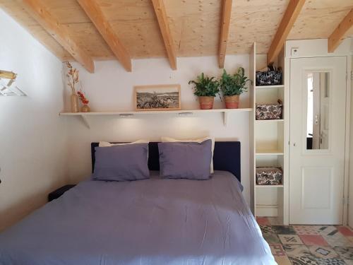 Stella Maris في أوديسْخيلد: غرفة نوم مع سرير مع وسائد أرجوانية