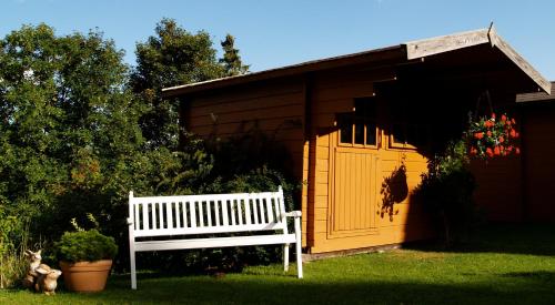a white bench sitting in front of a shed at Landhaus Lena in Schonwald im Schwarzwald