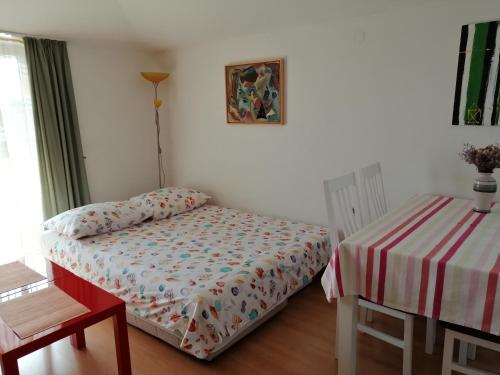 ein kleines Schlafzimmer mit einem Bett und einem Tisch in der Unterkunft Mladen in Fažana