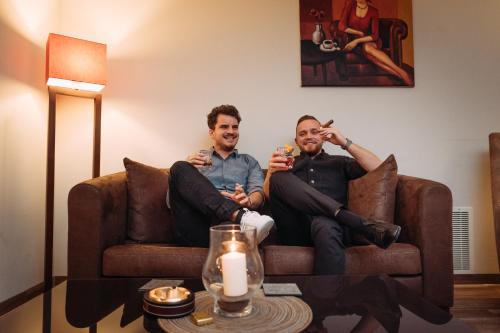 two men sitting on a couch drinking wine at Hotel Bären Titisee in Titisee-Neustadt