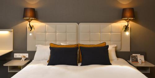 a bedroom with a large white bed with two lamps at Martin's Louvain-la-Neuve in Louvain-la-Neuve
