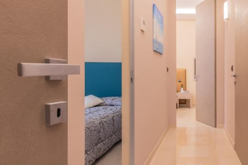 a bedroom with a bed and a door to a hallway at Luxury Maison - Appartamento di lusso a 50m dalla spiaggia in Grottammare