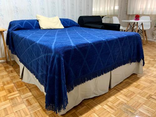 eine blaue Decke auf einem Bett in einem Zimmer in der Unterkunft DEPARTAMENTO COCA in Buenos Aires
