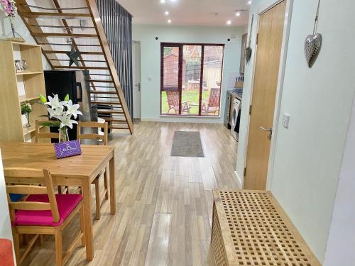 a living room with a wooden table and a staircase at Spacious 5 bed townhouse Manchester, Salford Qauys - Two Bedroom with Parking in Manchester