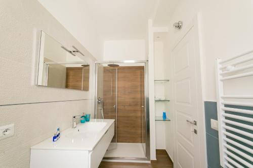ein weißes Bad mit einem Waschbecken und einer Dusche in der Unterkunft My place in Bari