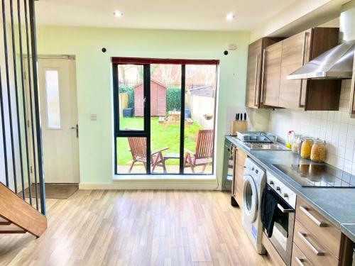 a kitchen with an open door to a yard at Spacious 5 bed townhouse Manchester, Salford Qauys - Two Bedroom with Parking in Manchester