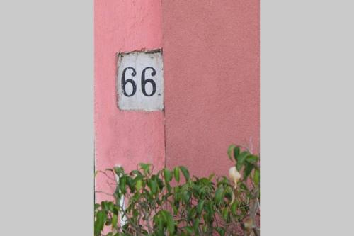 a pink wall with a house with a number on it at L angolo segreto di Giovanni il Pescatore in Procida