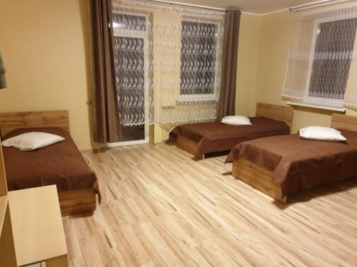 a room with two beds and a window at Babilonas in Plungė