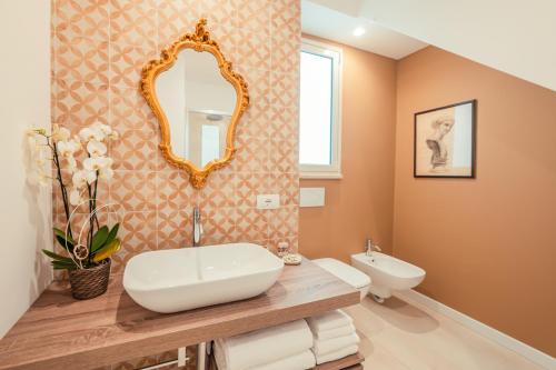un baño con lavabo y espejo en TaoApartments - Casa Antonella, en Taormina