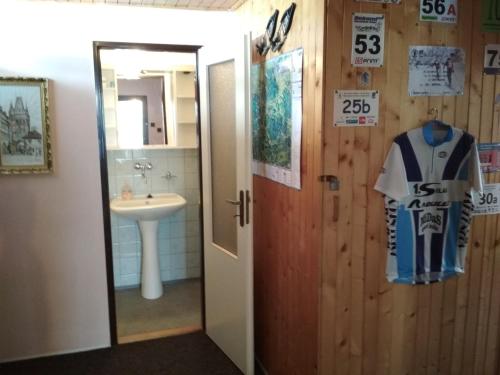 La salle de bains est pourvue d'un lavabo et d'une chemise suspendue à une porte. dans l'établissement Chalupa Na Křemence, à Třinec